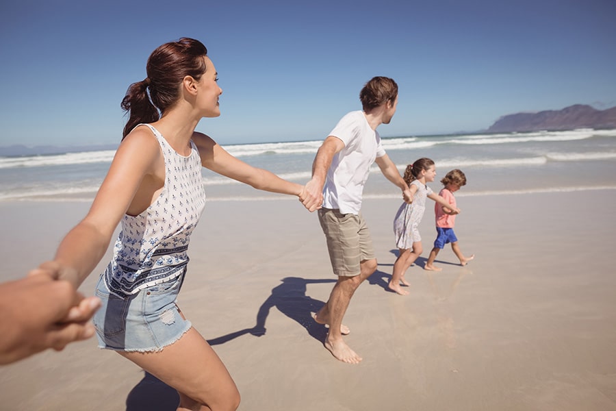 people on a beach, holding hands together